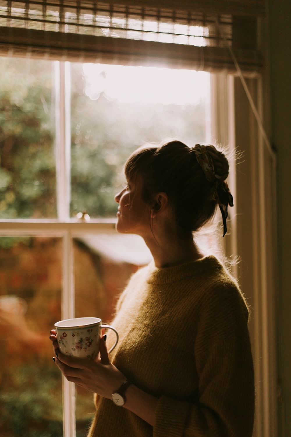 Mujer pensativa junto a una ventana